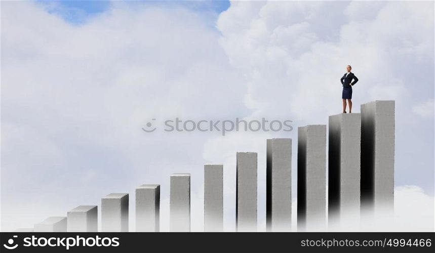Confident businesswoman on top. Businesswoman with hands on waist standing on graph bar