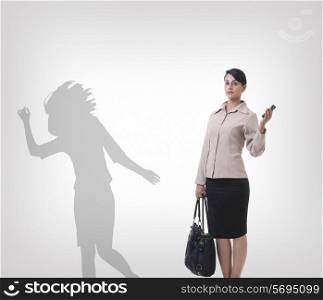 Confident businesswoman standing against shadow dancing over gray background