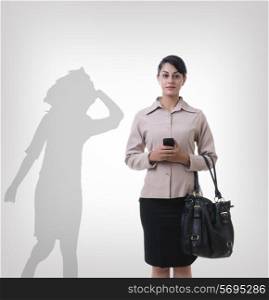 Confident businesswoman standing in front of shadow dancing over gray background