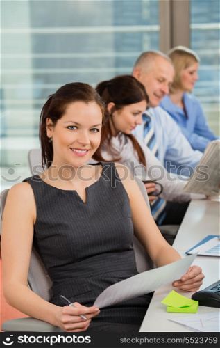 Confident businesswoman with colleagues in office