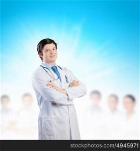 Confident doctor. Image of happy confident doctor in uniform with colleagues at background