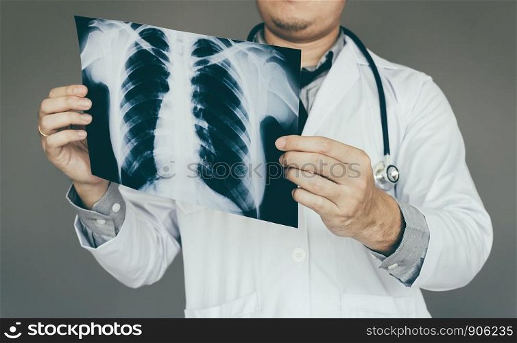 confident doctor man holding x-ray film in lab room.