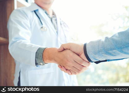 Confident Doctor shaking hands with patients talk in the hospital