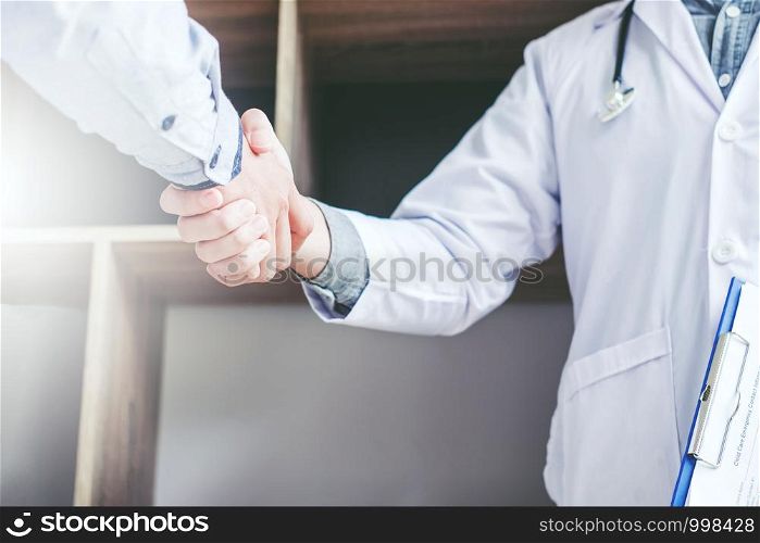Confident Doctor shaking hands with patients talk in the hospital