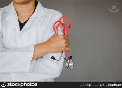 Confident doctor standing and holding stethoscope working at a hospital.