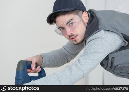 confident handsome young craftsman in workshop