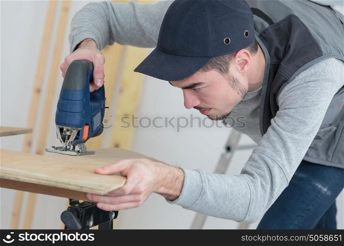 confident handsome young craftsman in workshop