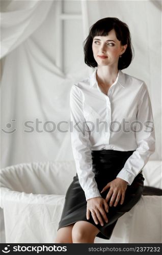 Confident happy attractive business woman. elegant Girl in white shirt and leather skirt sitting at home office.. Confident happy attractive business woman. elegant Girl in white shirt and leather skirt sitting at home office