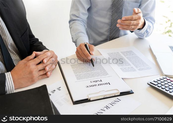 Confident insurance agent broker man holding document and present pointing showing an insurance policy contract form to client Business Communication Connection Concept