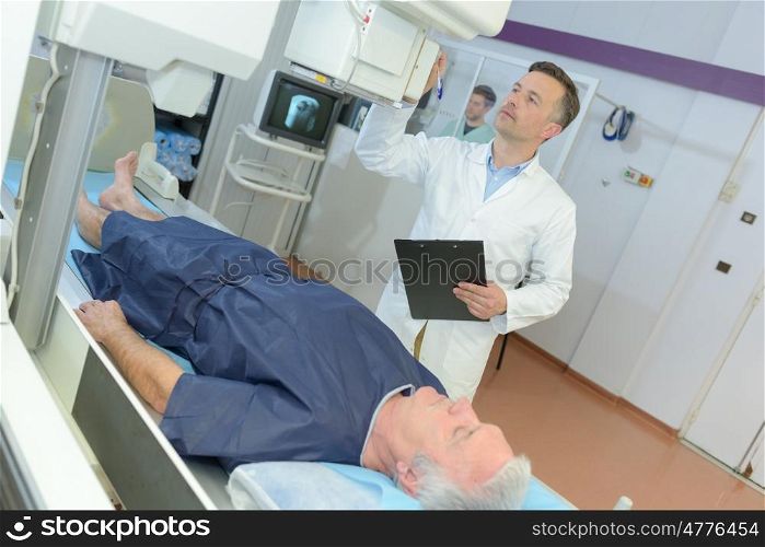 confident male doctor in hospital with patient undergoing mri