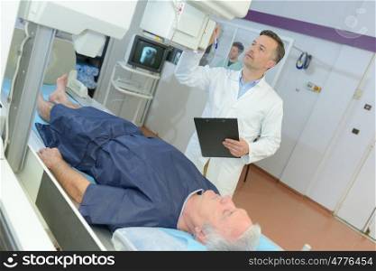 confident male doctor in hospital with patient undergoing mri