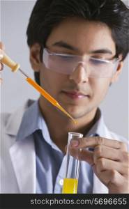 Confident male scientist adding liquid to the test tube