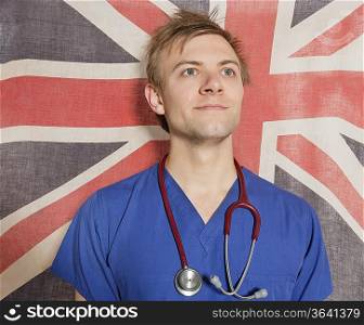 Confident male surgeon looking up with British Flag in background