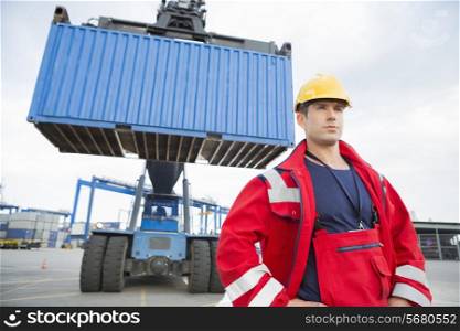 Confident male worker standing in front of freight vehicle at shipyard
