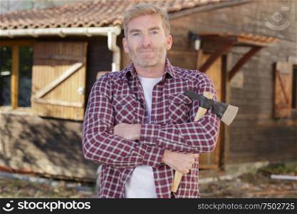 confident man standing with axe outdoors