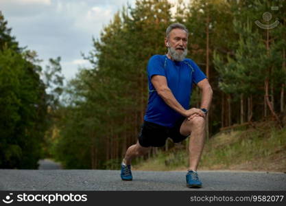 Confident mature retired athlete warming up muscles before running practice. Everyday sport routine for healthcare and wellness on retirement. Confident mature retired athlete warming up muscles before running