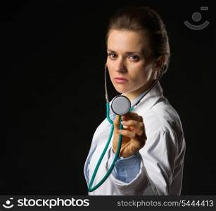 Confident medical doctor woman using stethoscope isolated on black