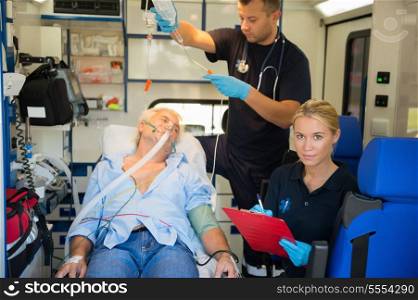 Confident paramedic treating injured elderly patient on stretcher in ambulance