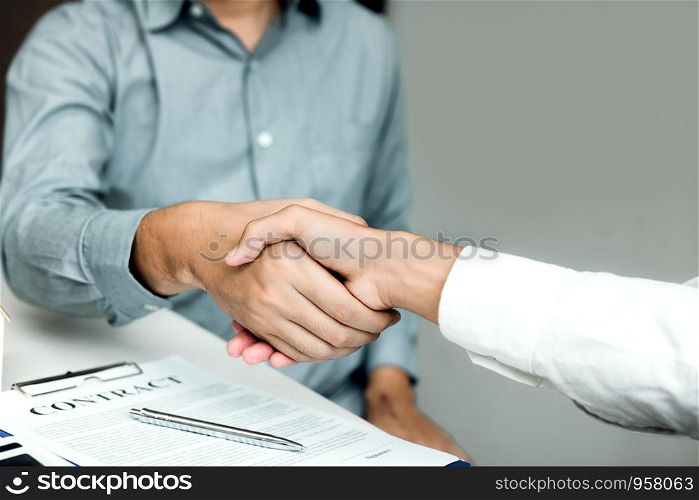 Confident partnerships people shaking hands with making a contract in the office.