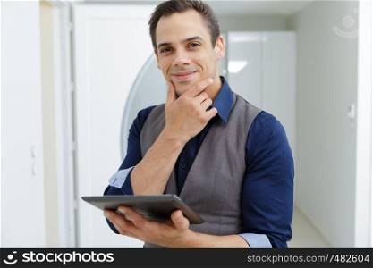 confident real estate agent holding tablet