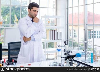 Confident scientist portrait of Happy male scientist keeping arms crossed in a chemistry lab scientist holding test tube with sample in Laboratory analysis background