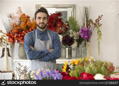 confident smiling young male florist with colorful flowers his shop
