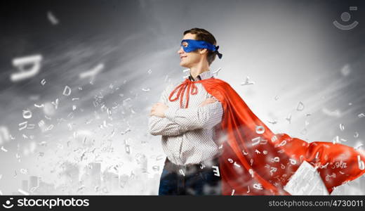 Confident superhero. Young man wearing superman mask and cape