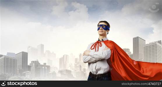 Confident superhero. Young man wearing superman mask and cape