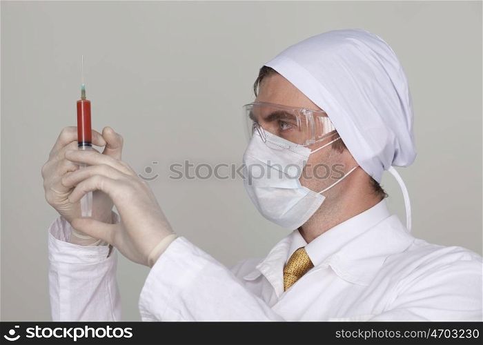 Confident surgeon holding a syringe against a white background