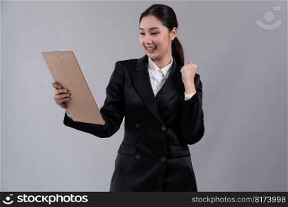 Confident young asian businesswoman in formal suit holding clipboard with hand gesture indicating promotion or advertising with surprised facial expression on isolated background. Enthusiastic. Confident young asian businesswoman making hand gesture. Enthusiastic