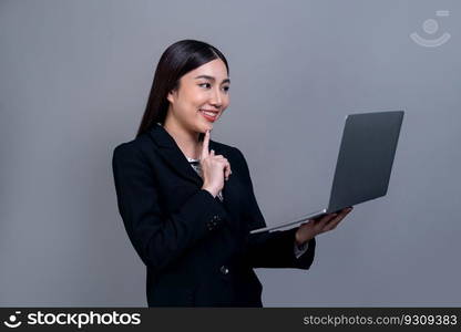 Confident young Asian businesswoman posing with laptop on isolated background. Office lady make hand holding gesture for promotions sales, technology advertisements or HR recruitment image. Jubilant. Office lady make hand holding gesture for advertisements with laptop. Jubilant