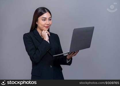 Confident young Asian businesswoman posing with laptop on isolated background. Office lady make hand holding gesture for promotions sales, technology advertisements or HR recruitment image. Jubilant. Office lady make hand holding gesture for advertisements with laptop. Jubilant