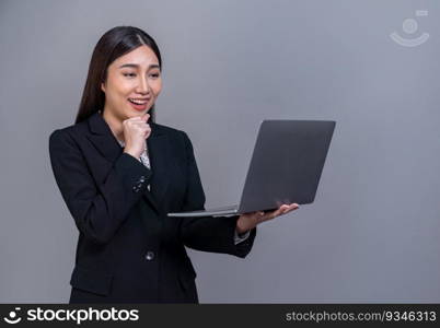 Confident young Asian businesswoman posing with laptop on isolated background. Office lady make hand holding gesture for promotions sales, technology advertisements or HR recruitment image. Jubilant. Office lady make hand holding gesture for advertisements with laptop. Jubilant