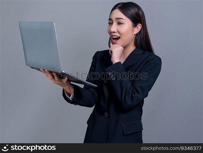Confident young Asian businesswoman posing with laptop on isolated background. Office lady make hand holding gesture for promotions sales, technology advertisements or HR recruitment image. Jubilant. Office lady make hand holding gesture for advertisements with laptop. Jubilant