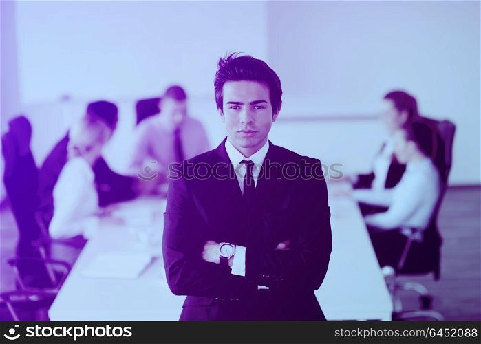 Confident young business man attending a meeting with his colleagues