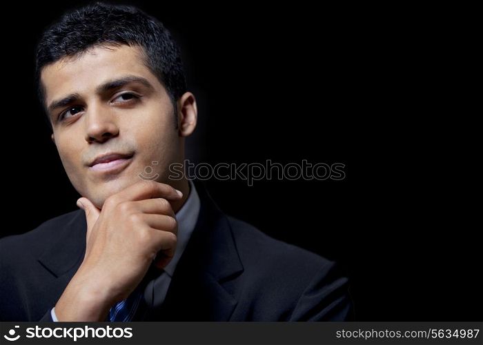 Confident young business man over black background