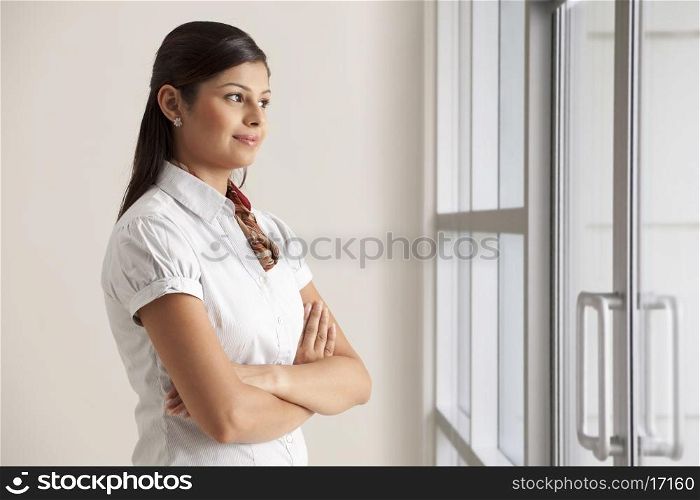 Confident young business woman thinking while looking out