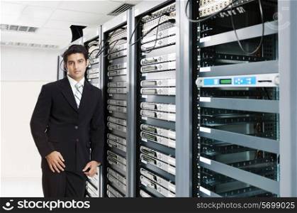 Confident young businessman in server room