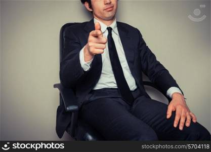 Confident young businessman is sitting in an office chair