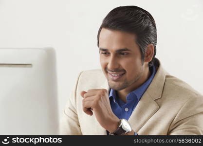 Confident young businessman using computer in office