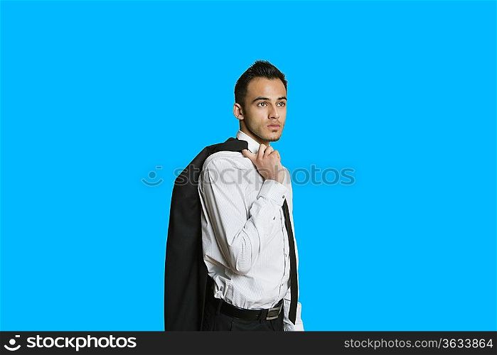 Confident young businessman with suit over shoulder on colored background