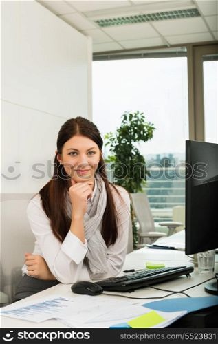Confident young businesswoman sitting at office desk