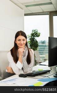 Confident young businesswoman sitting at office desk