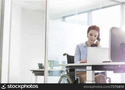 Confident young disabled businesswoman working at desk in office