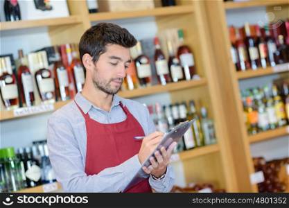 confident young sommelier writing something at his note pad