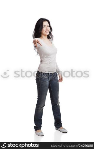 Confident young woman po∫ing to you, isolated against white background