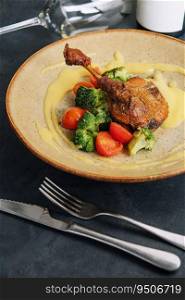 Confit duck leg with broccoli and tomatoes
