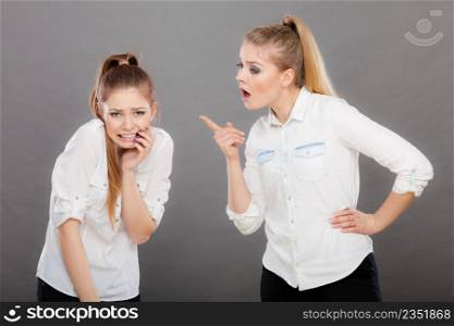 Conflict, bad relationships, friendship difficulties. Two young women having argument. Angry fury girl screaming at her friend or younger sister. Angry fury girl screaming at her friend or younger sister