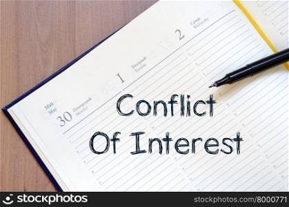 Conflict of interest text concept write on notebook with pen