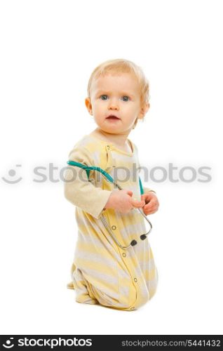 Confused baby with stethoscope sitting on floor isolated on white